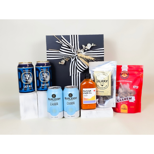 Gift set with beer cans, a bottle, and snack packages on a white background