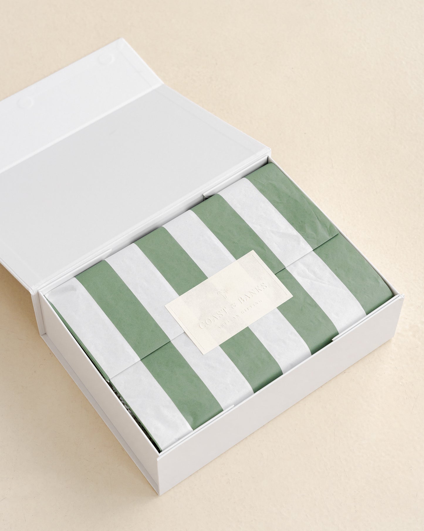Green and white striped fabric in a white box on a beige background