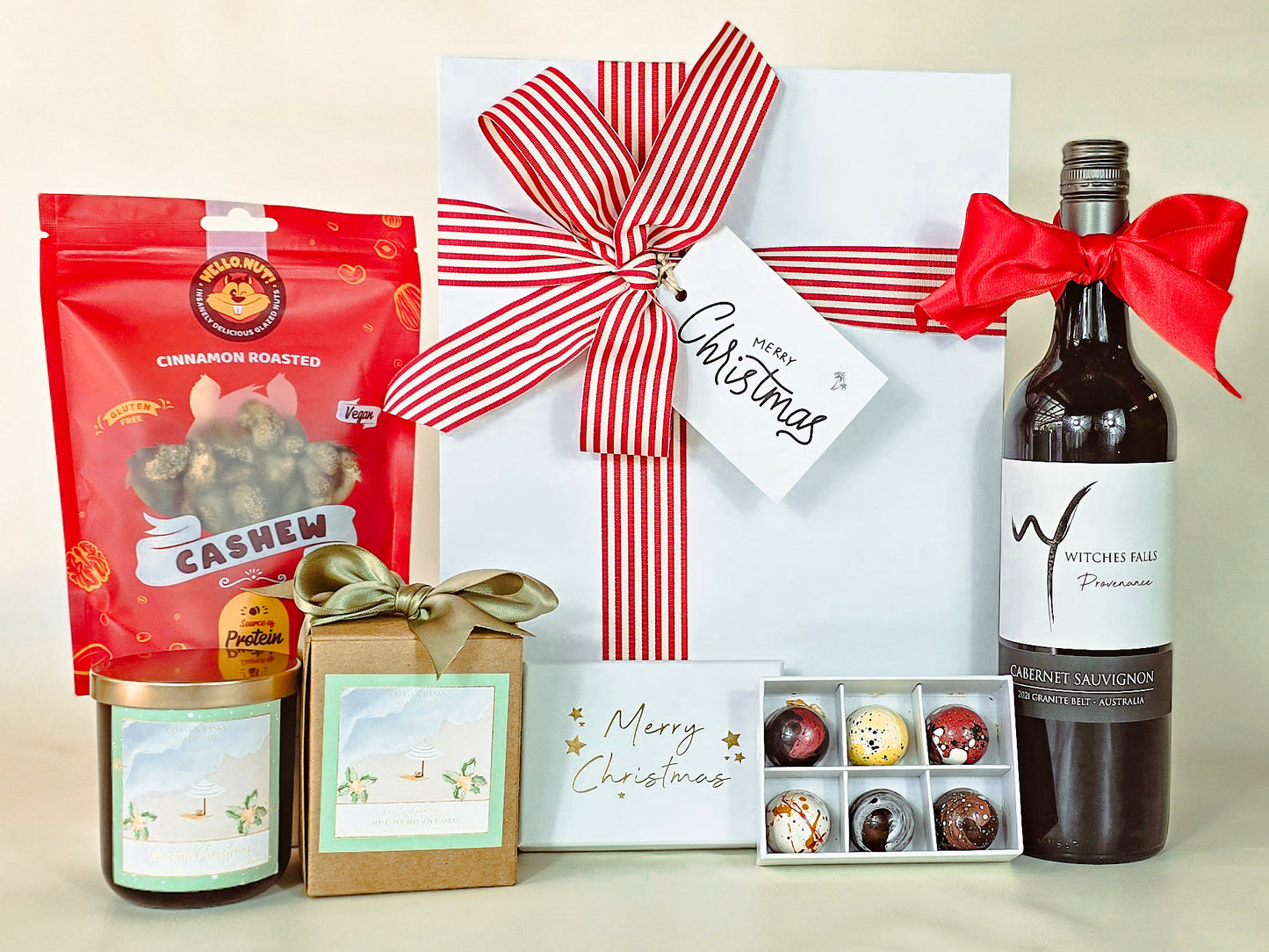 Gift basket with cashews, wine, and other items on a light background