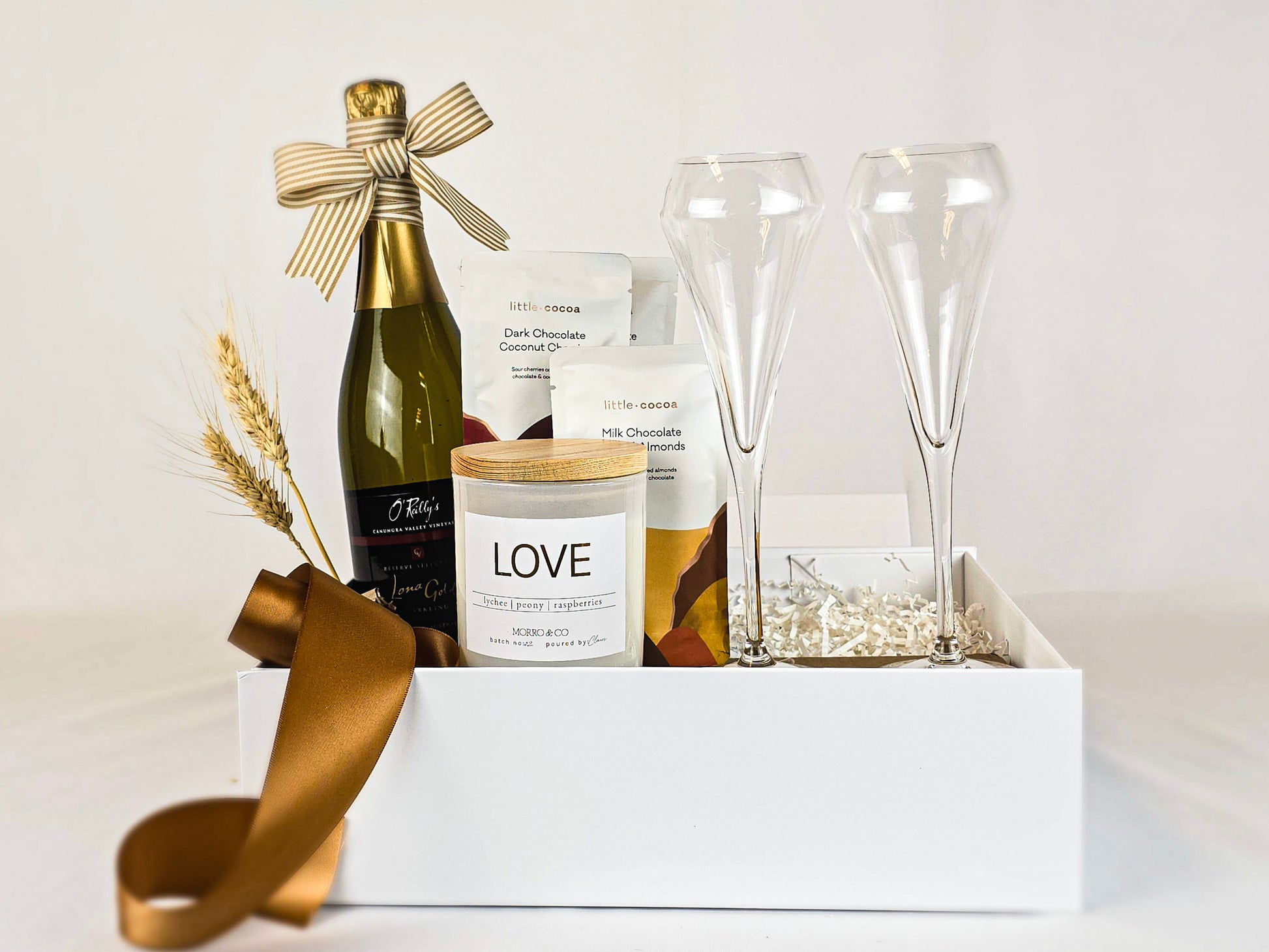 Sparkling wine, 2 crystal flutes, candle and chocolates.