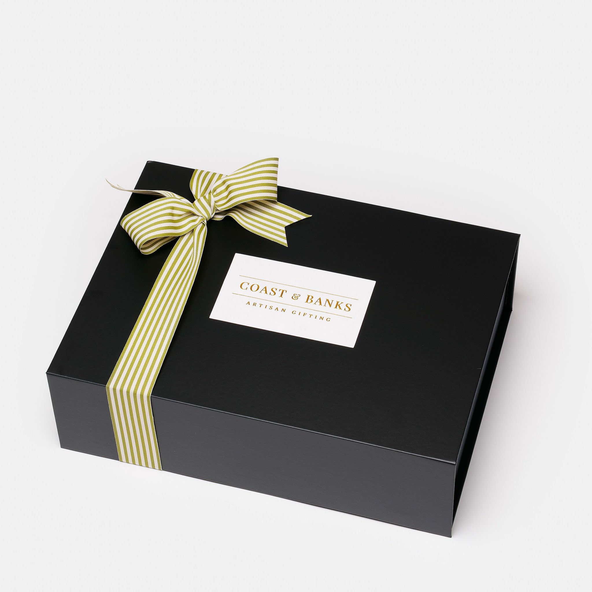 Black gift box with a yellow and white striped ribbon and 'Coast & Banks' label on a light gray background