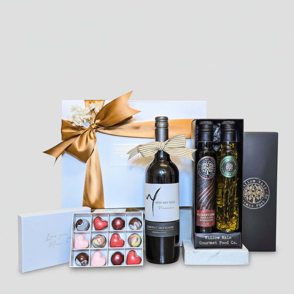 Gift set with wine, chocolates, and olive oil on a wooden surface