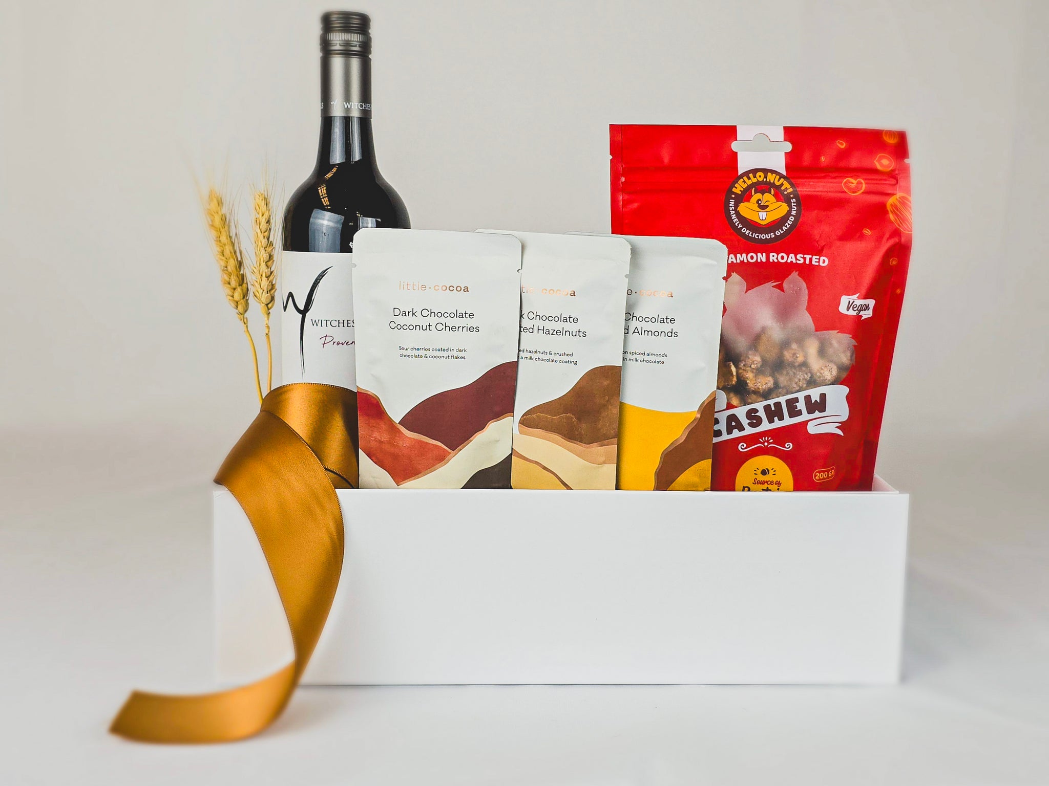 Gift hamper with red wine, chocolates and cinnamon cashews.